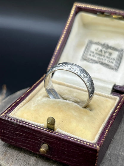 An engraved platinum wedding band ring, in an antique ring box