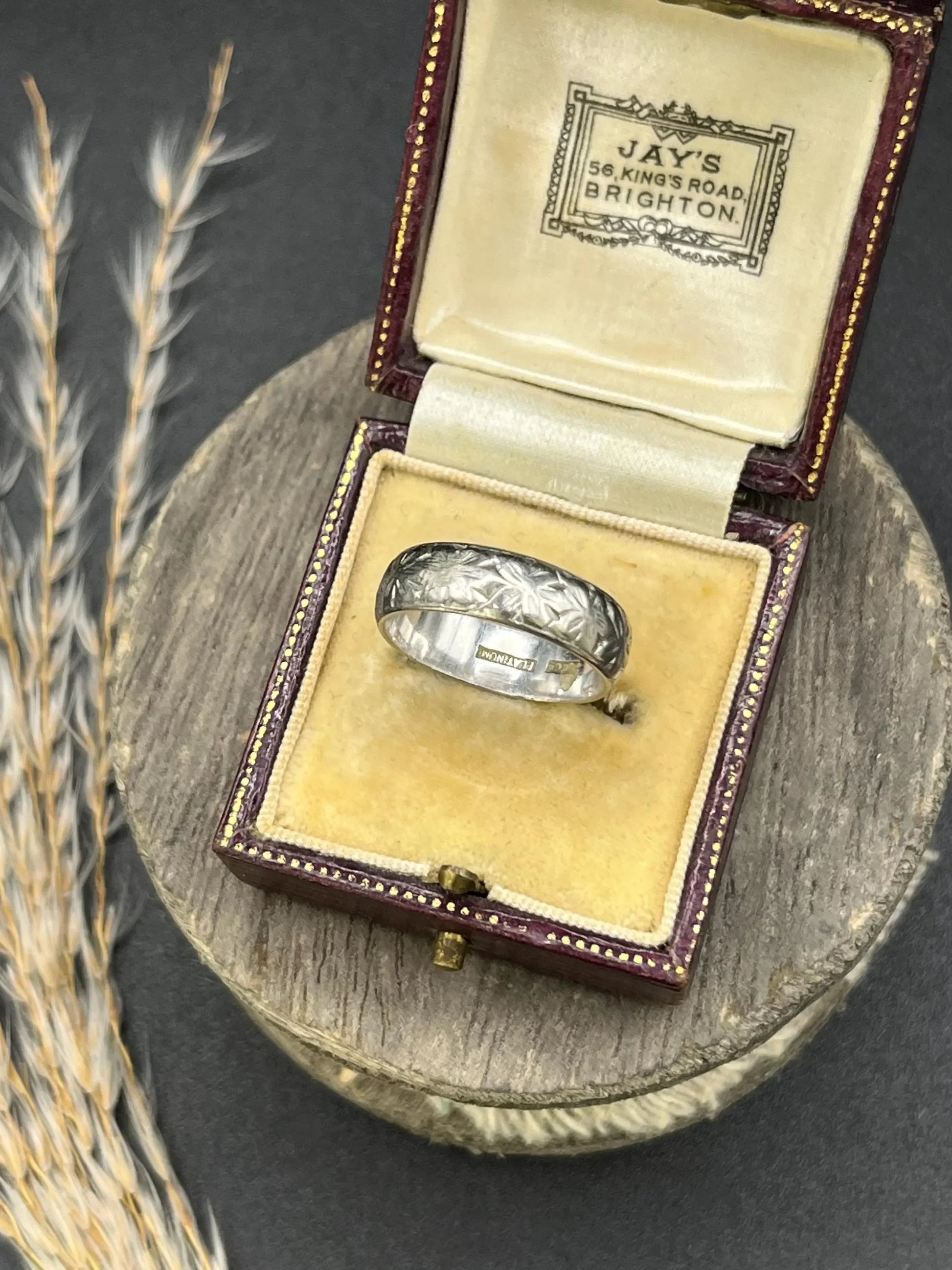 An engraved platinum wedding band ring, in an antique ring box