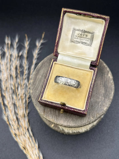 An engraved platinum wedding band ring, in an antique ring box