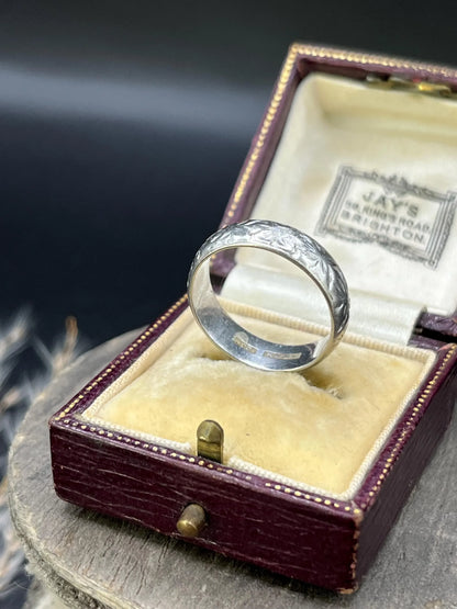 An engraved platinum wedding band ring, in an antique ring box