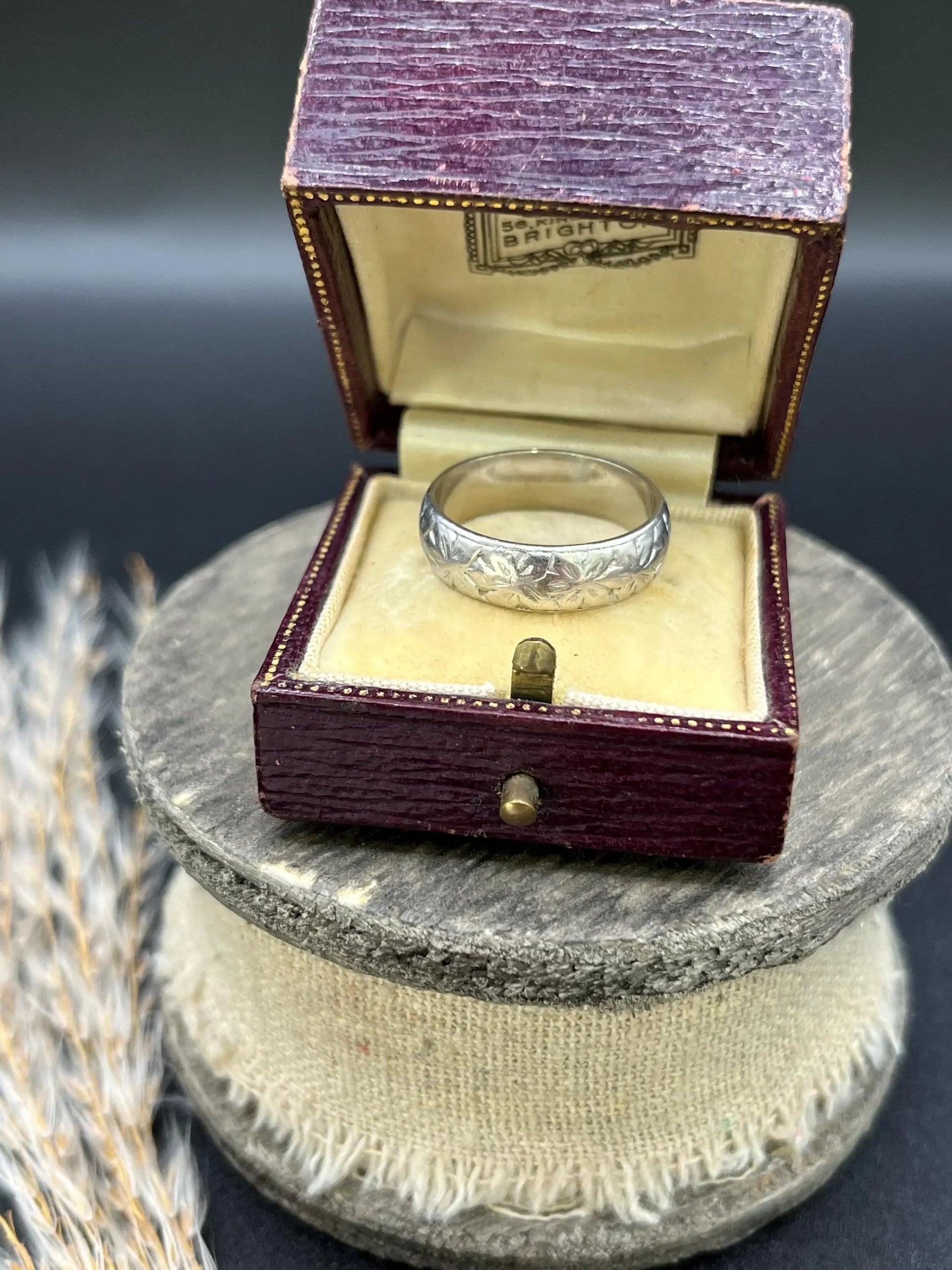 An engraved platinum wedding band ring, in an antique ring box