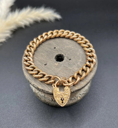 A rose gold curb link bracelet with engraved heart padlock clasp