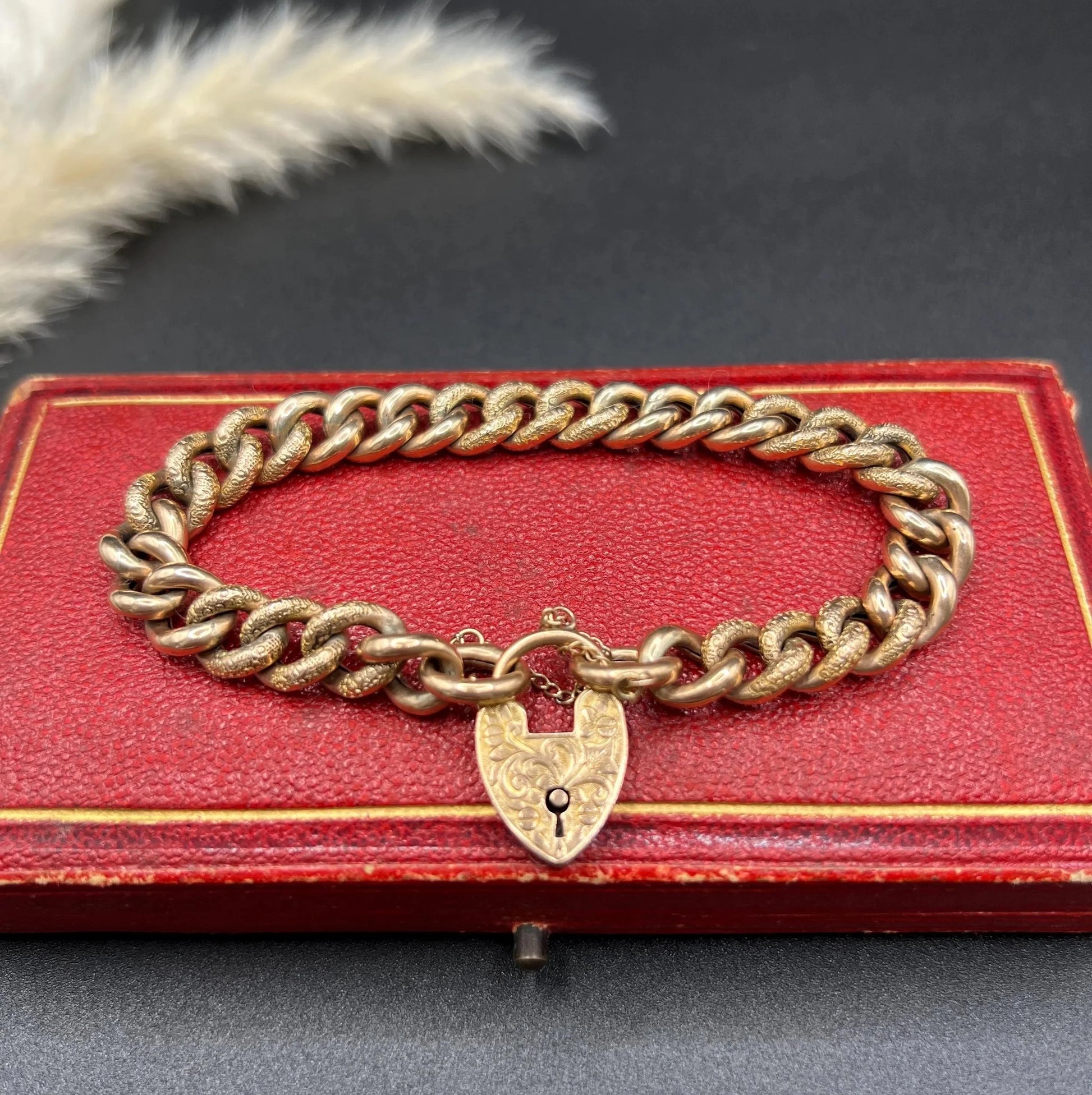 A rose gold curb link bracelet with engraved heart padlock clasp