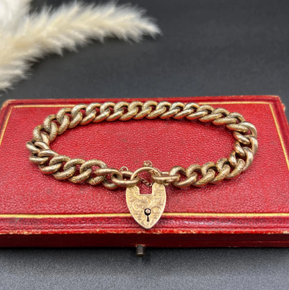 A rose gold curb link bracelet with engraved heart padlock clasp