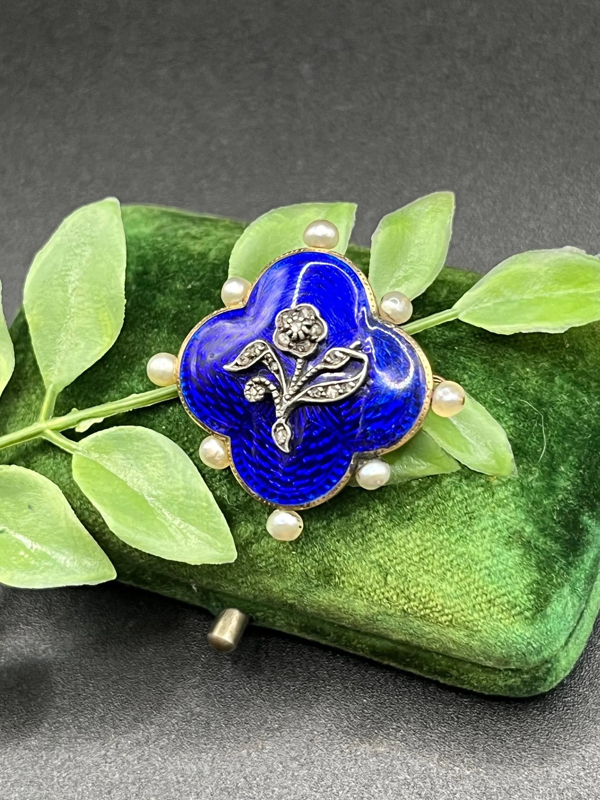 A diamond flower, blue enamel and pearl brooch in yellow gold