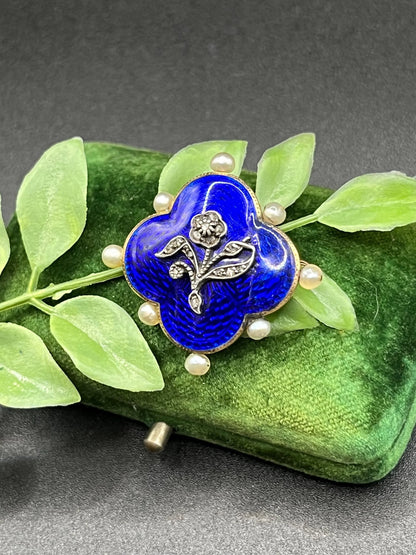 A diamond flower, blue enamel and pearl brooch in yellow gold