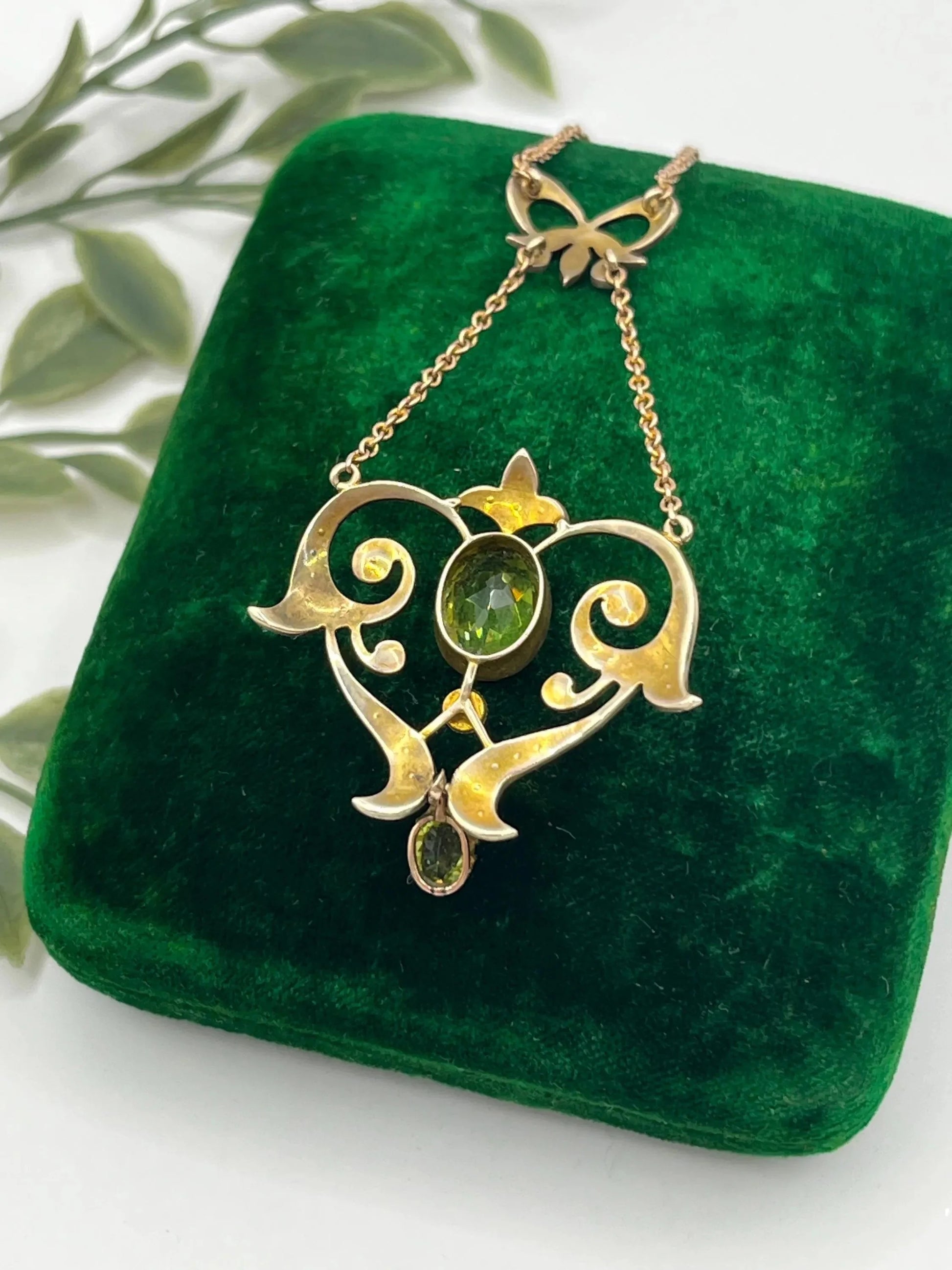 A yellow gold peridot and seed pearl pendant necklace