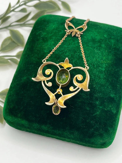 A yellow gold peridot and seed pearl pendant necklace
