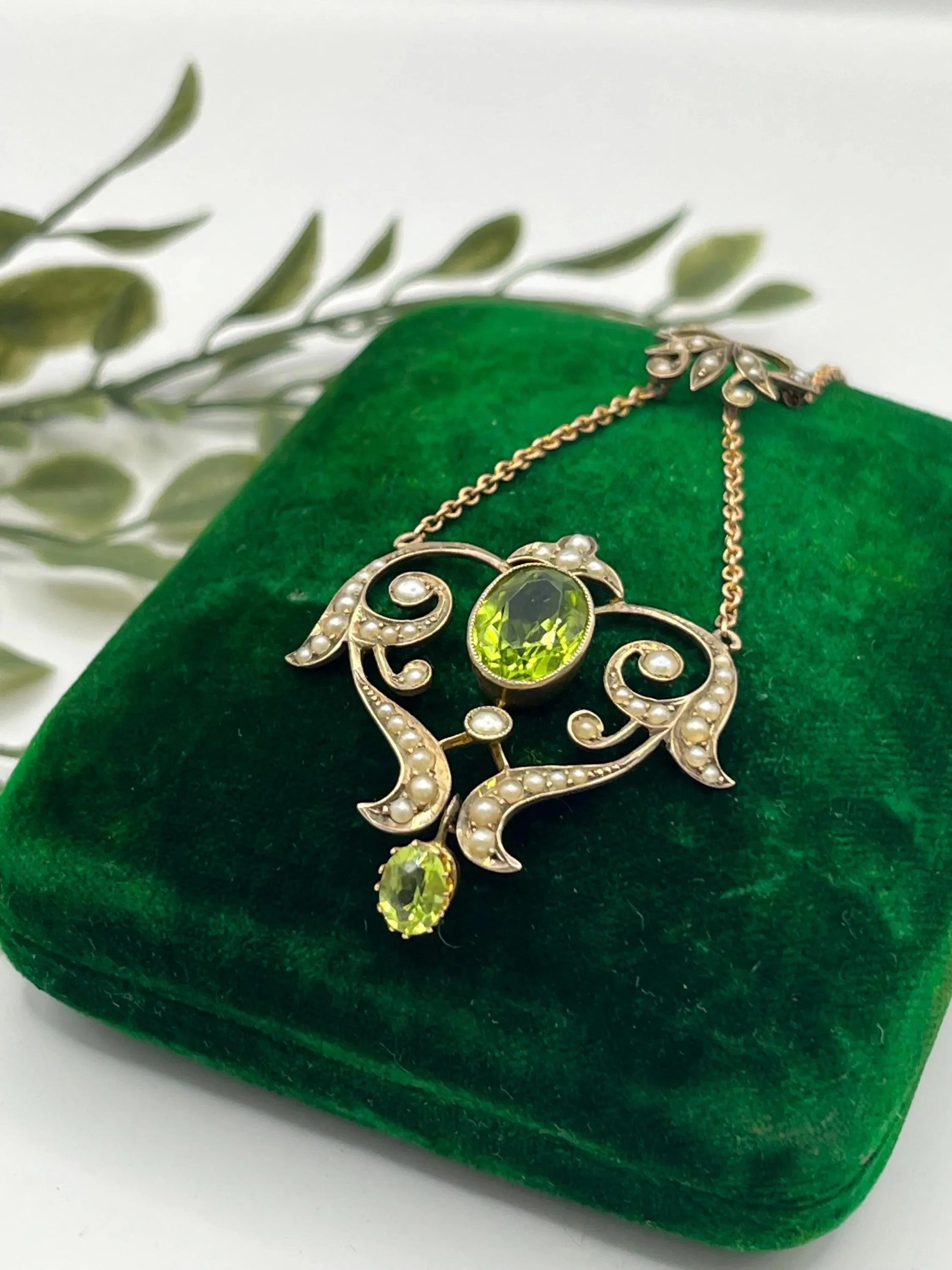 A yellow gold peridot and seed pearl pendant necklace