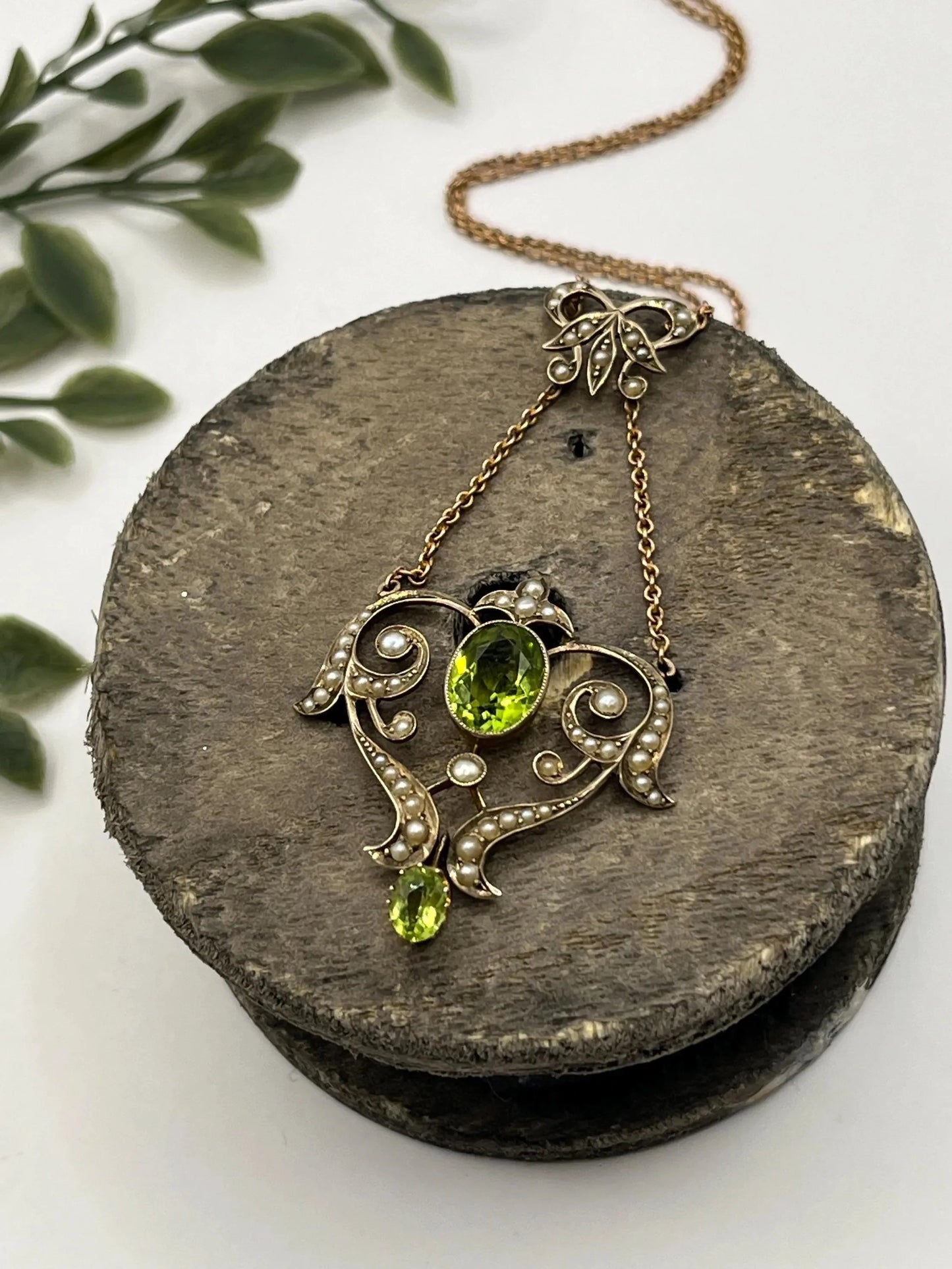 A yellow gold peridot and seed pearl pendant necklace