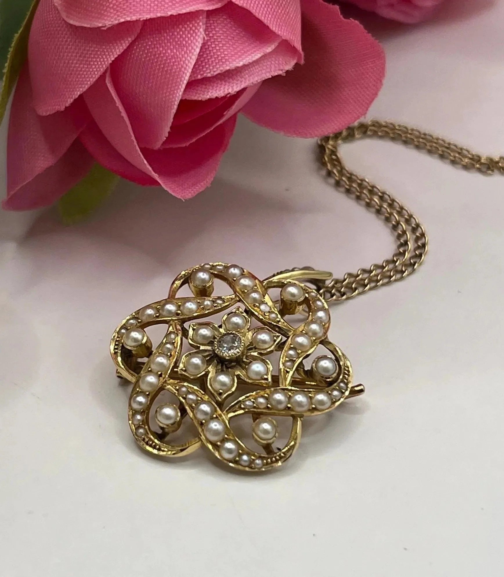 A yellow gold seed pearl and diamond floral brooch/pendant, with a gold chain
