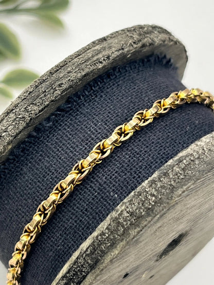A yellow gold chain necklace with a heart shaped padlock clasp