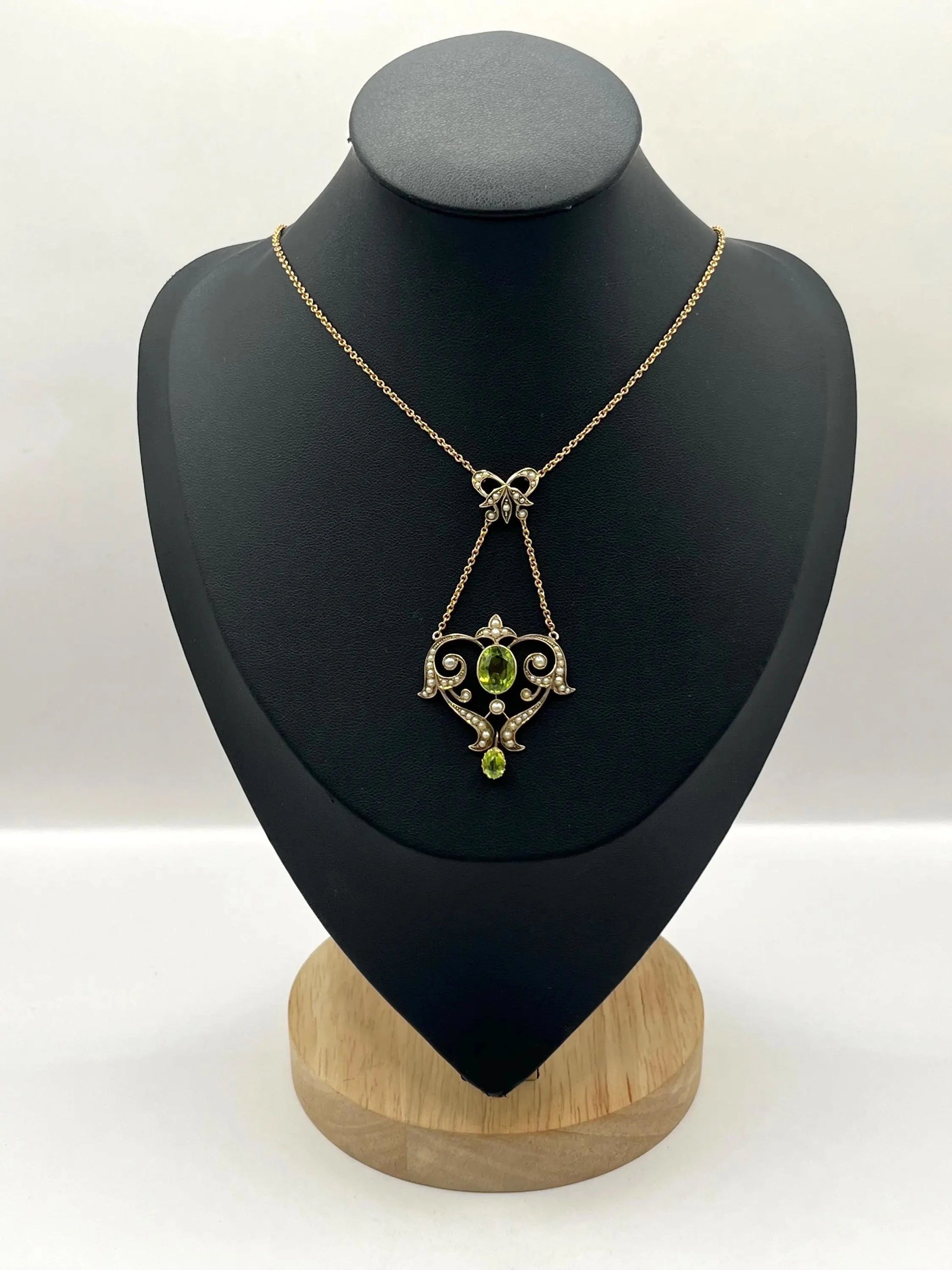 A yellow gold peridot and seed pearl pendant necklace