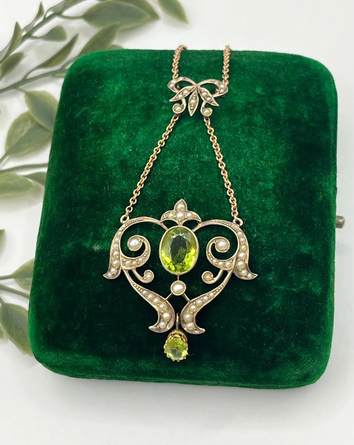 A yellow gold peridot and seed pearl pendant necklace