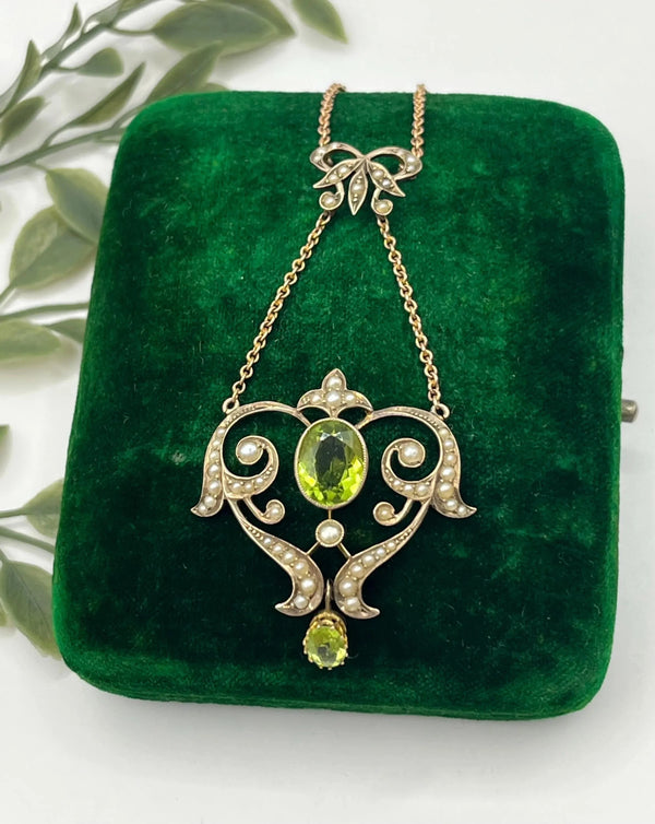 A yellow gold peridot and seed pearl pendant necklace