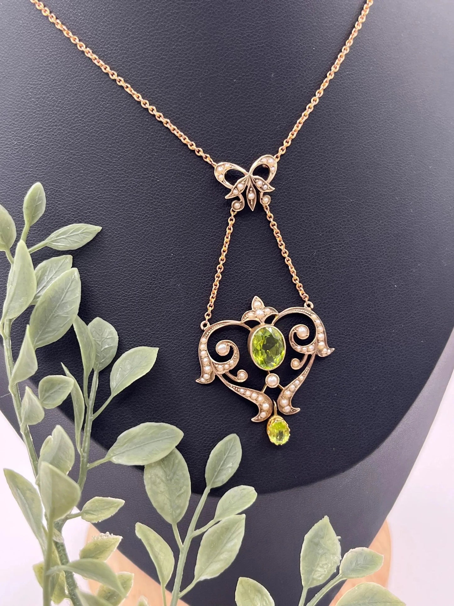A yellow gold peridot and seed pearl pendant necklace