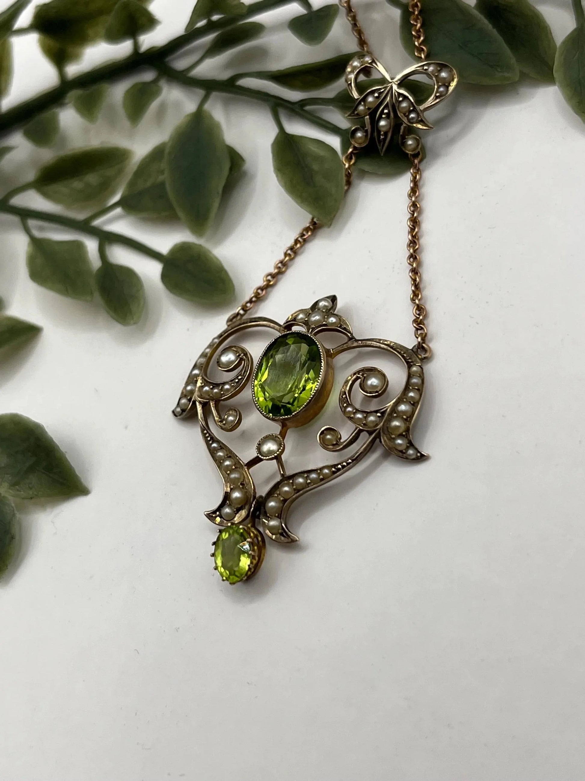 A yellow gold peridot and seed pearl pendant necklace