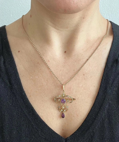 A yellow gold amethyst and seed pearl pendant/brooch, with a gold chain, modelled by a woman wearing a black top