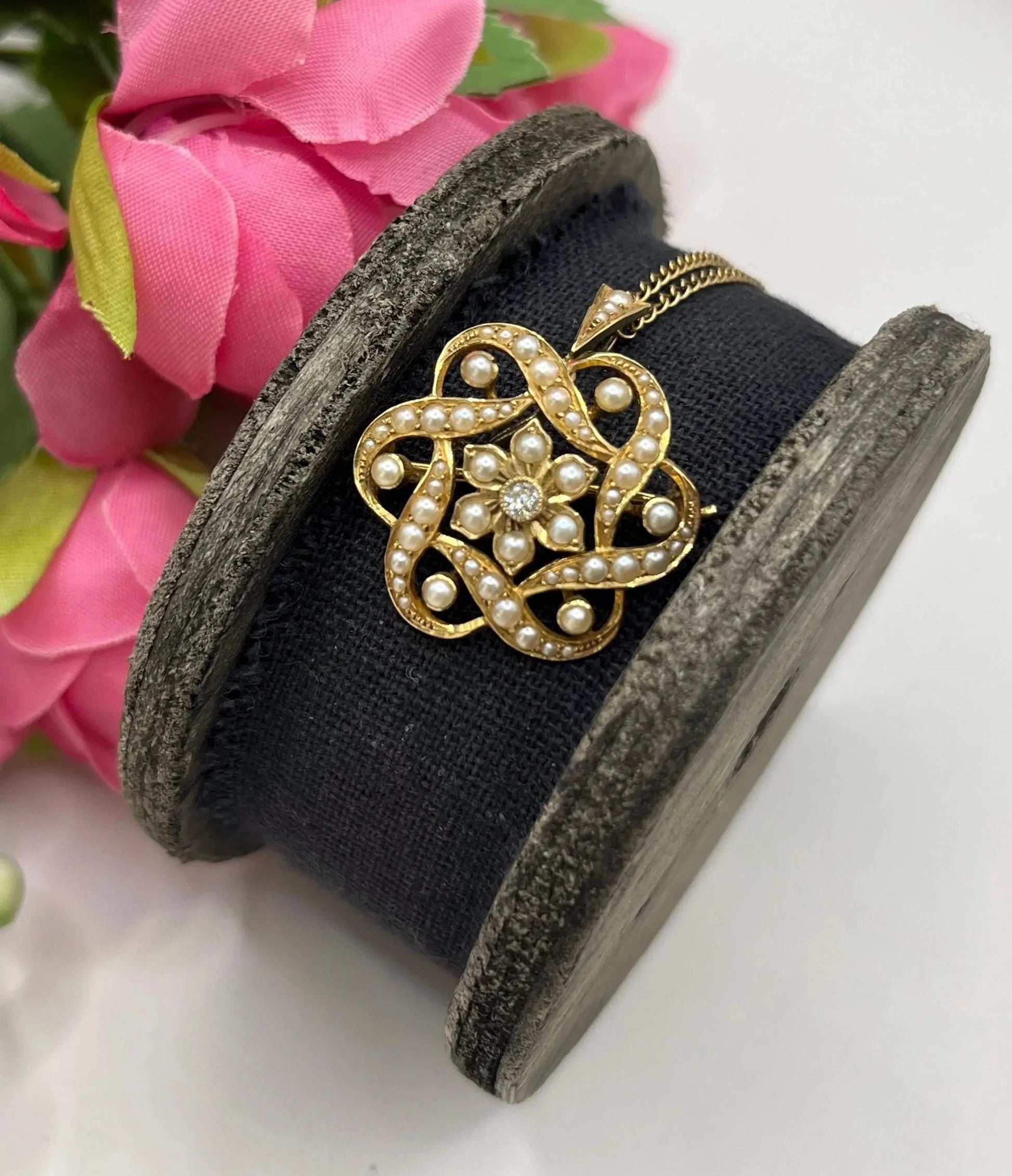 A yellow gold seed pearl and diamond floral brooch/pendant, with a gold chain