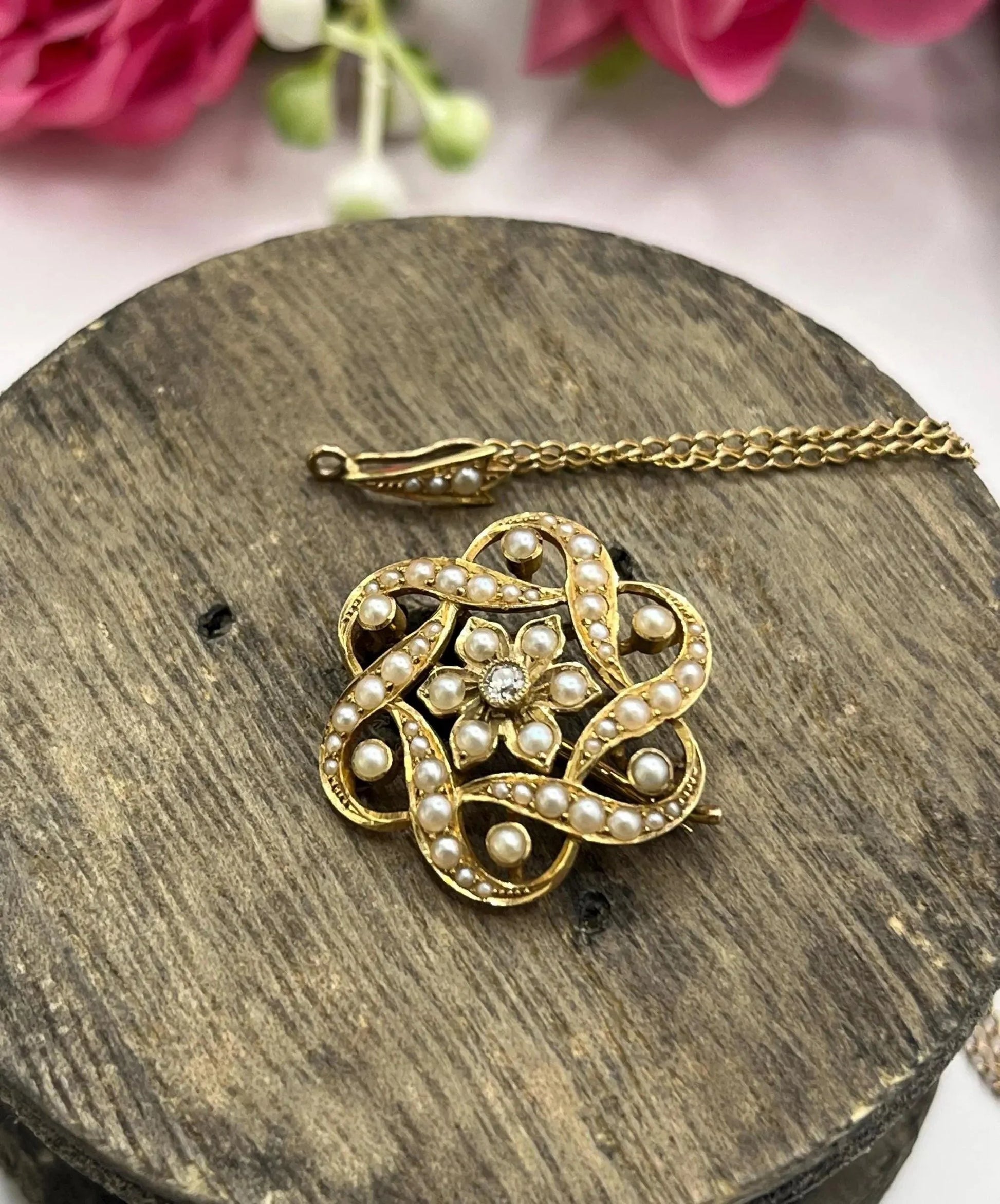 A yellow gold seed pearl and diamond floral brooch/pendant, with a gold chain