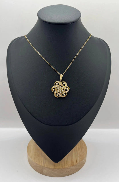 A yellow gold seed pearl and diamond floral brooch/pendant, with a chain, modelled on a black jewellery bust