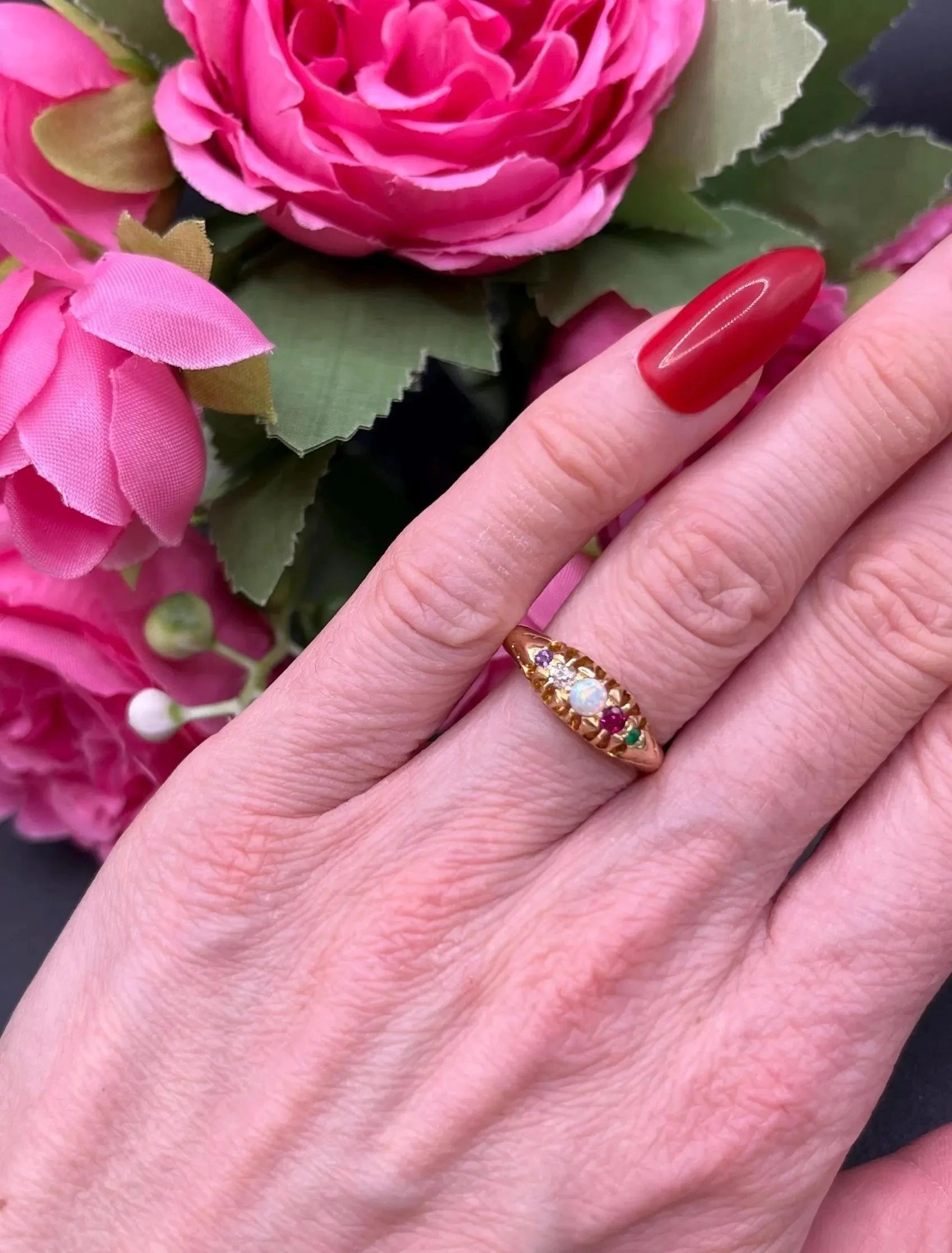 A yellow gold multi-gemstone acrostic ring, modelled on a hand