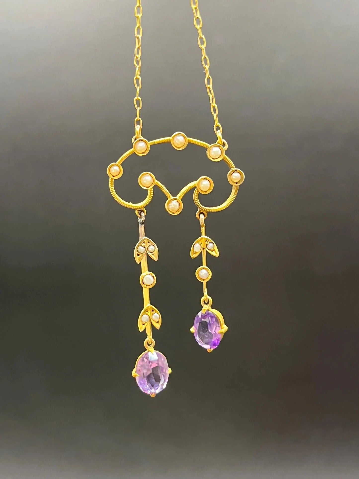 An amethyst and seed pearl drop pendant necklace in yellow gold
