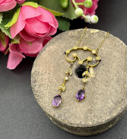 An amethyst and seed pearl drop pendant necklace in yellow gold