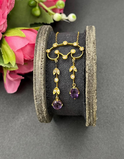 An amethyst and seed pearl drop pendant necklace in yellow gold