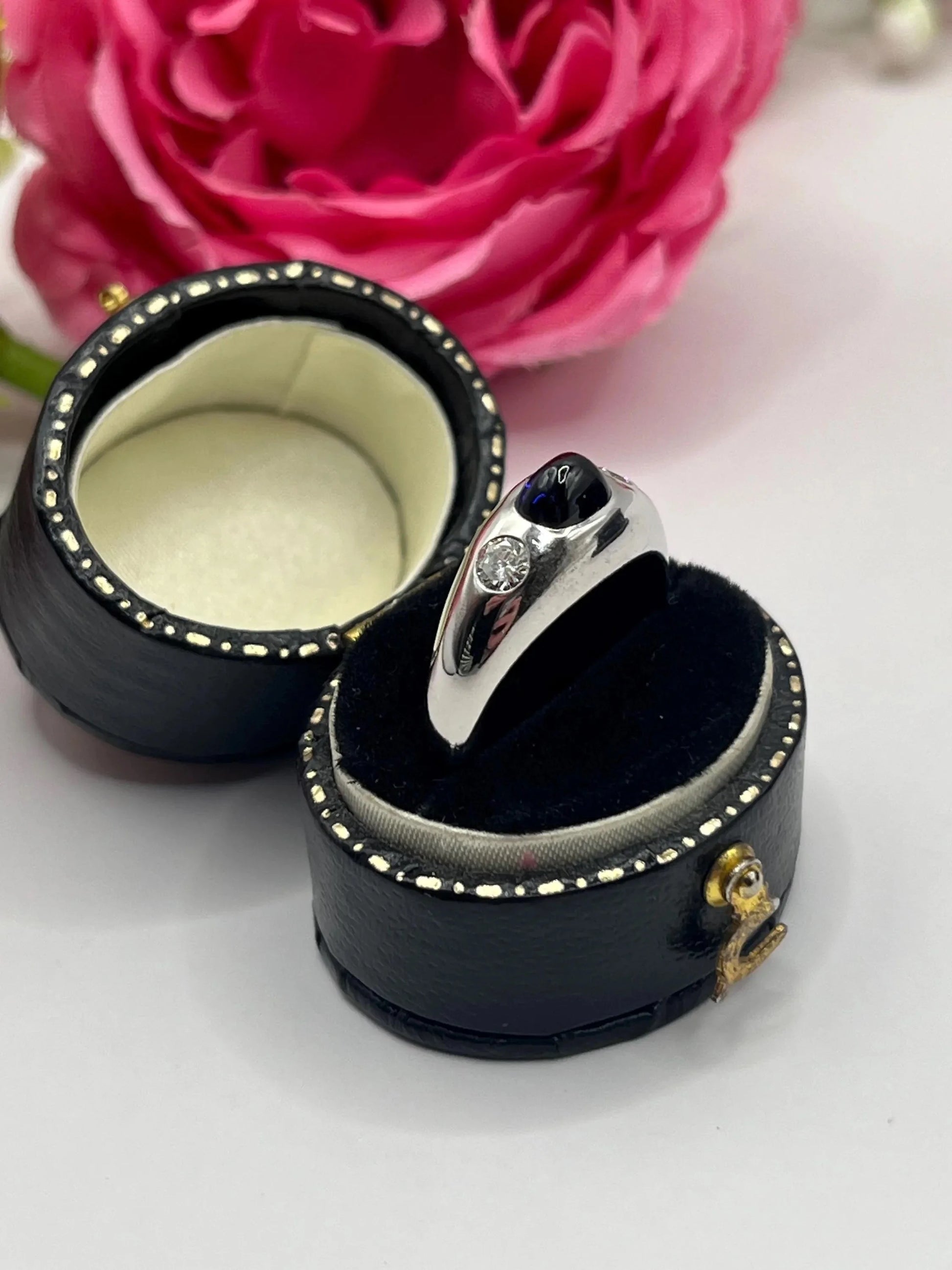 A cabochon sapphire and round diamond three stone band ring in white gold, in a ring box