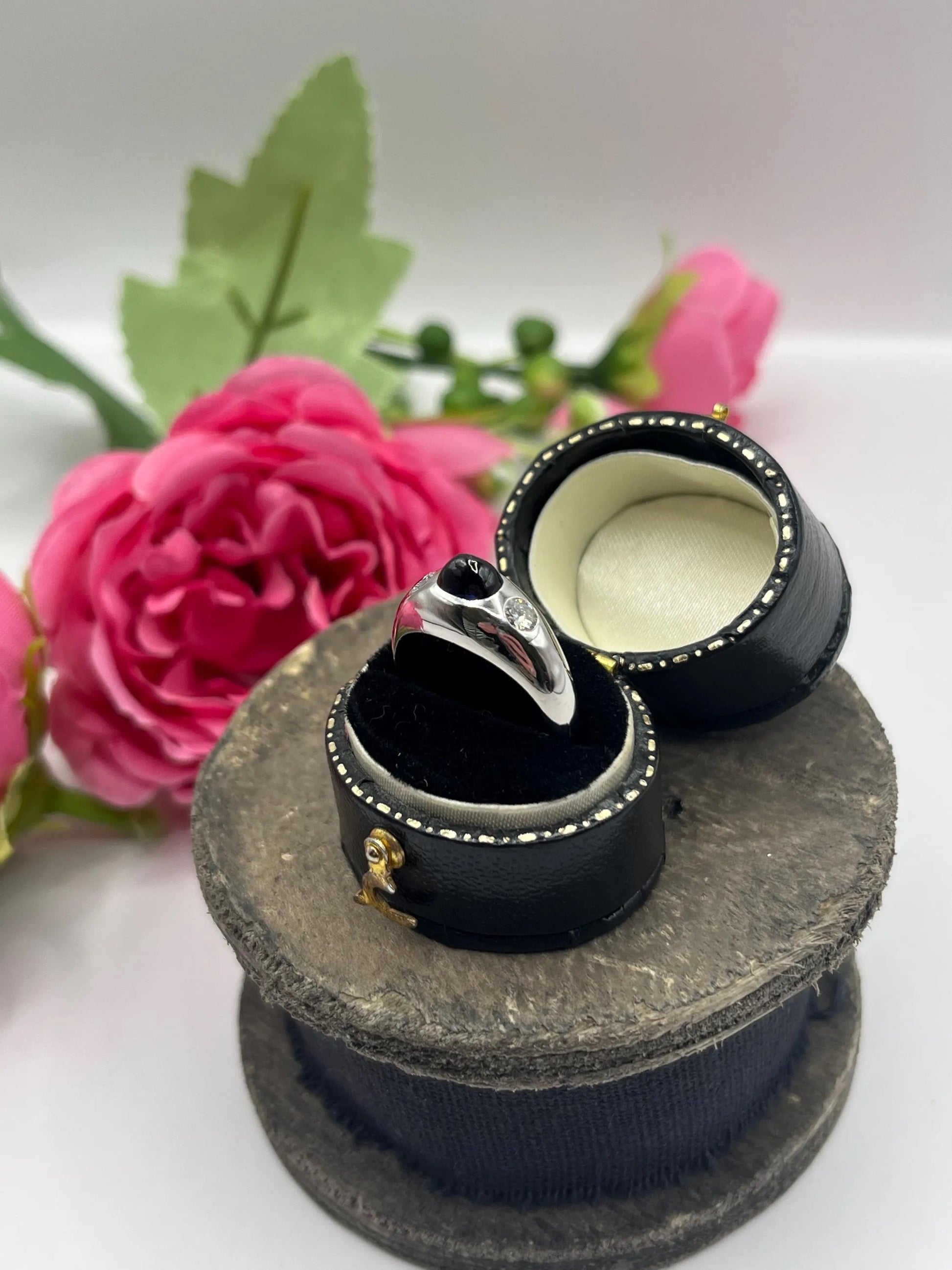 A cabochon sapphire and round diamond three stone band ring in white gold, in a ring box