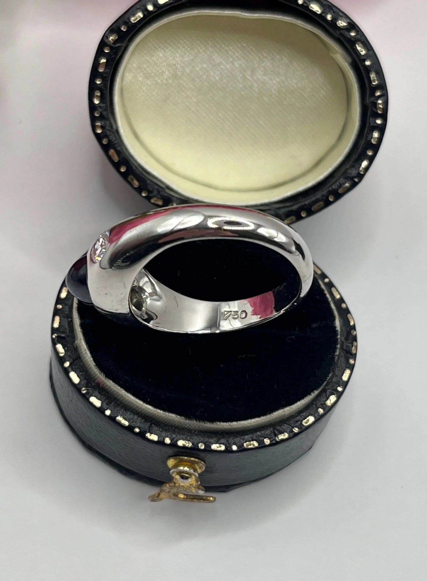 A cabochon sapphire and round diamond three stone band ring in white gold