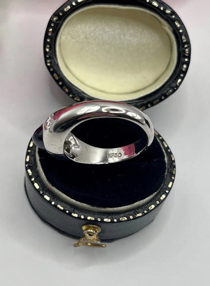 A cabochon sapphire and round diamond three stone band ring in white gold