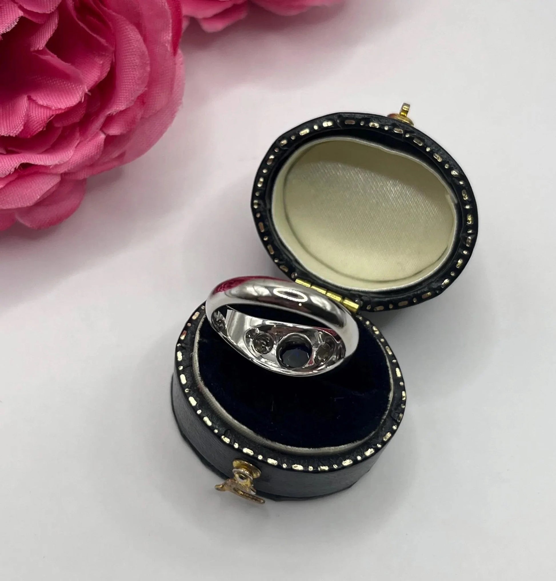 A cabochon sapphire and round diamond three stone band ring in white gold