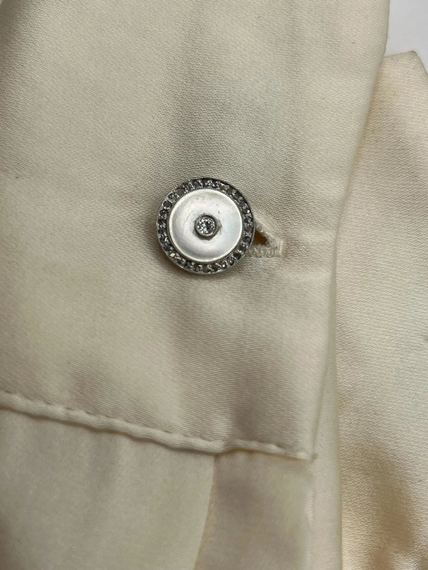 A round diamond and mother of pearl cufflink in yellow and white gold, modelled in a shirt cuff