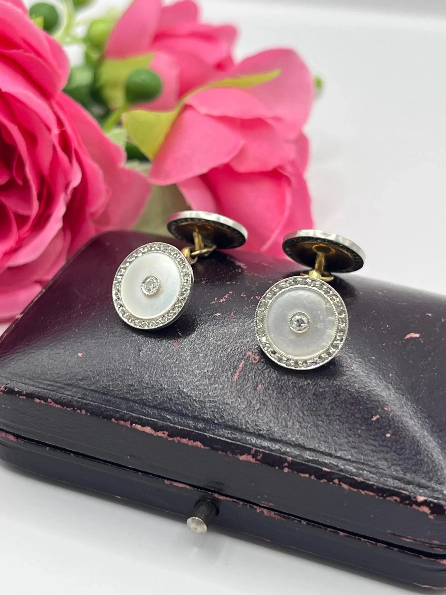 A pair of round diamond and mother of pearl cufflinks in yellow and white gold