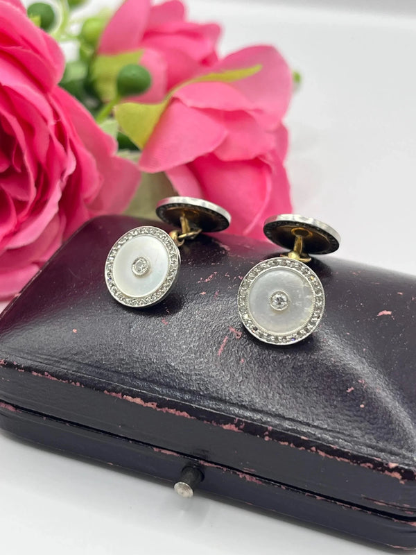 A pair of round diamond and mother of pearl cufflinks in yellow and white gold