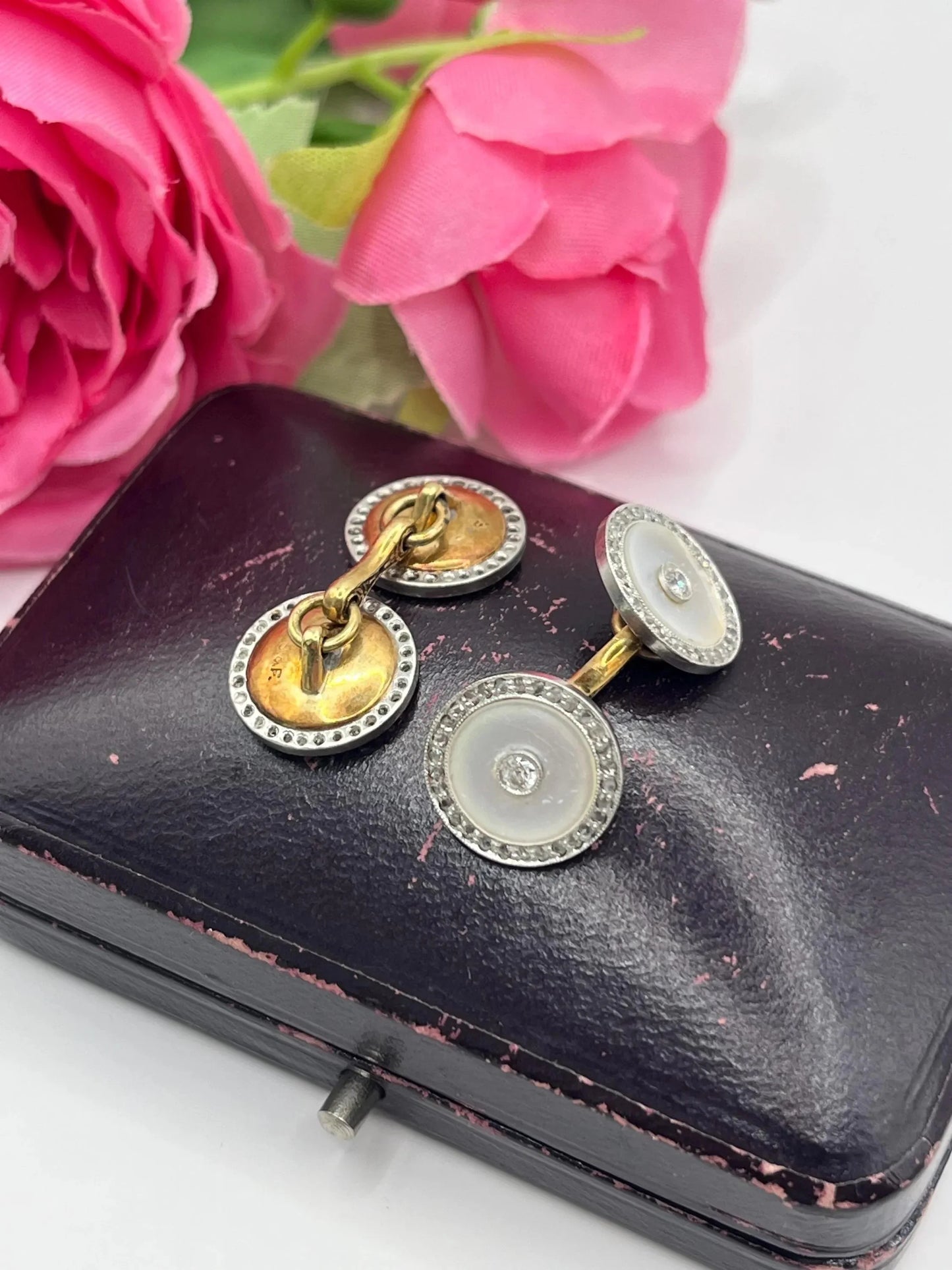 A pair of round diamond and mother of pearl cufflinks in yellow and white gold