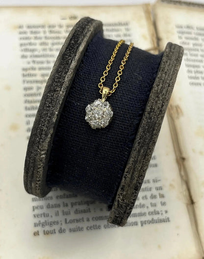A diamond cluster pendant in yellow and white gold with a yellow gold chain