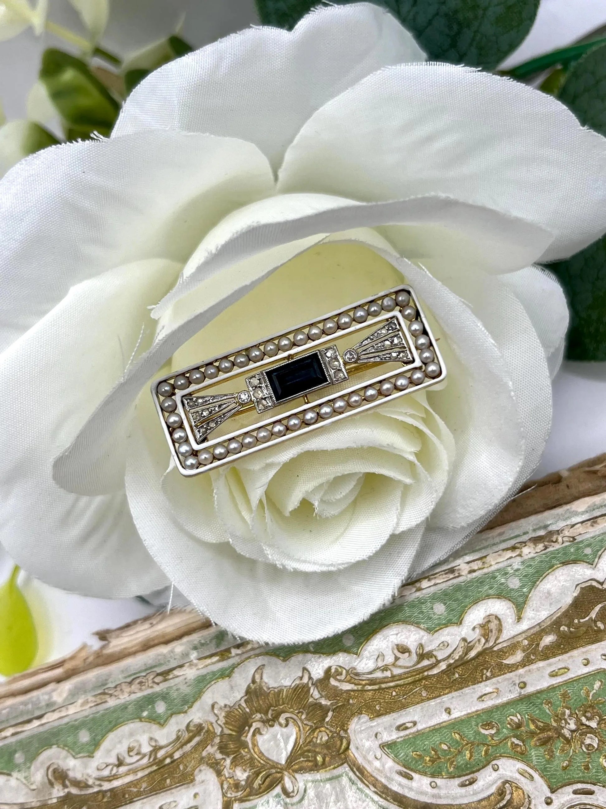 A rectangular brooch with sapphire, pearls and diamonds in gold and platinum, in a flower
