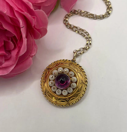 A round etruscan style pendant with a cabochon amethyst and carved coral in yellow gold, with a gold chain