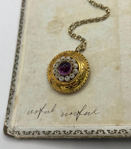 A round etruscan style pendant with a cabochon amethyst and carved coral in yellow gold, with a gold chain