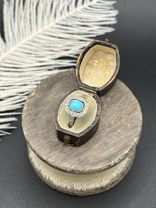 A turquoise and diamond cluster ring in platinum, in an antique ring box
