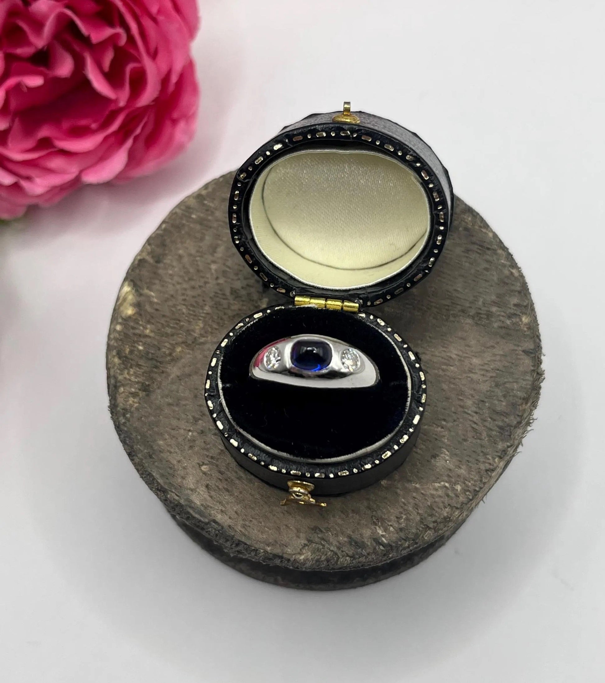 A cabochon sapphire and round diamond three stone band ring in white gold, in a ring box