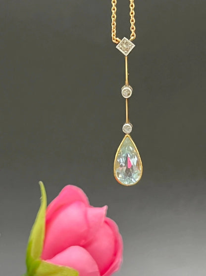 A pear shaped aquamarine and diamond drop pendant necklace in yellow gold