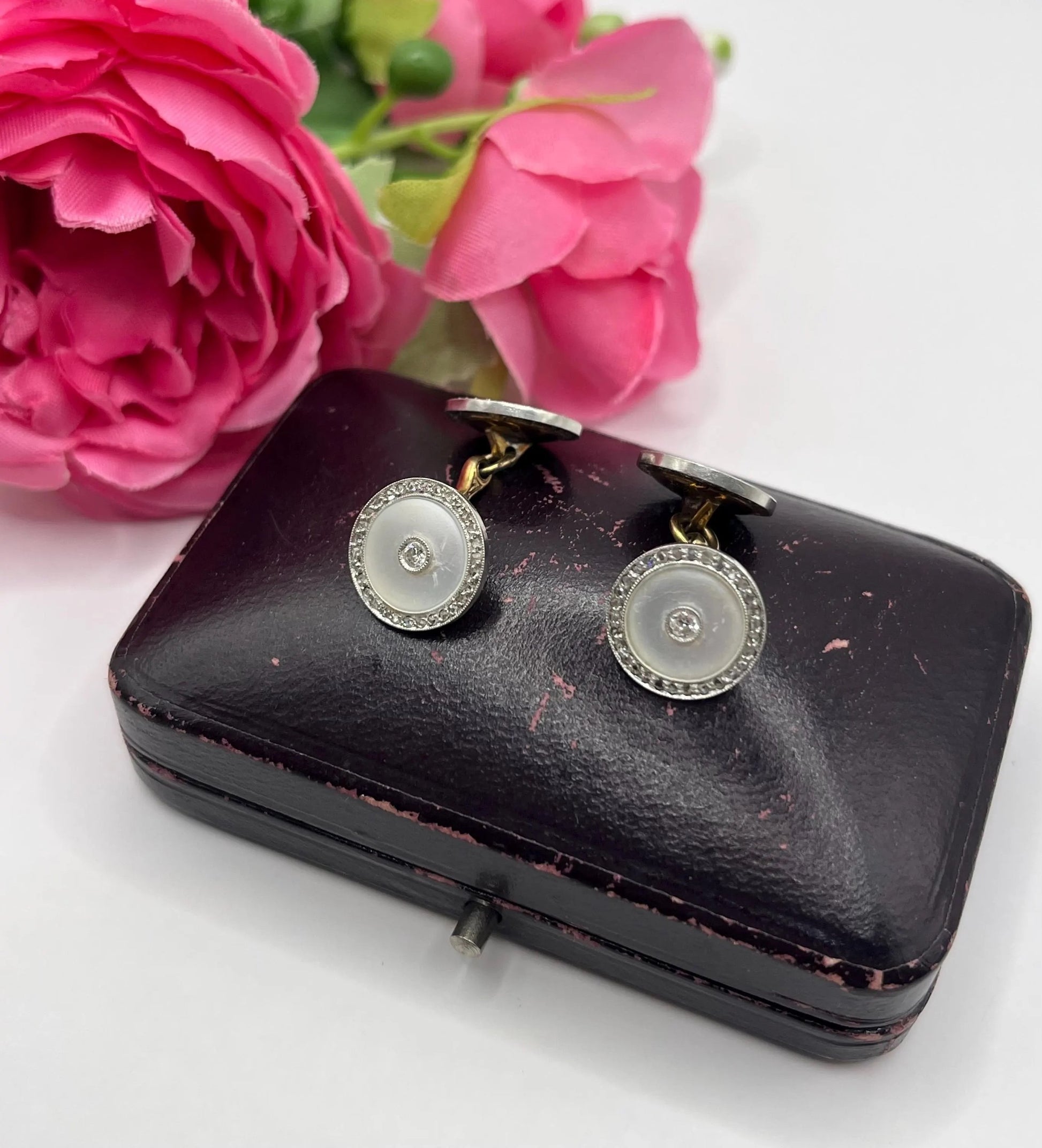A pair of round diamond and mother of pearl cufflinks in yellow and white gold