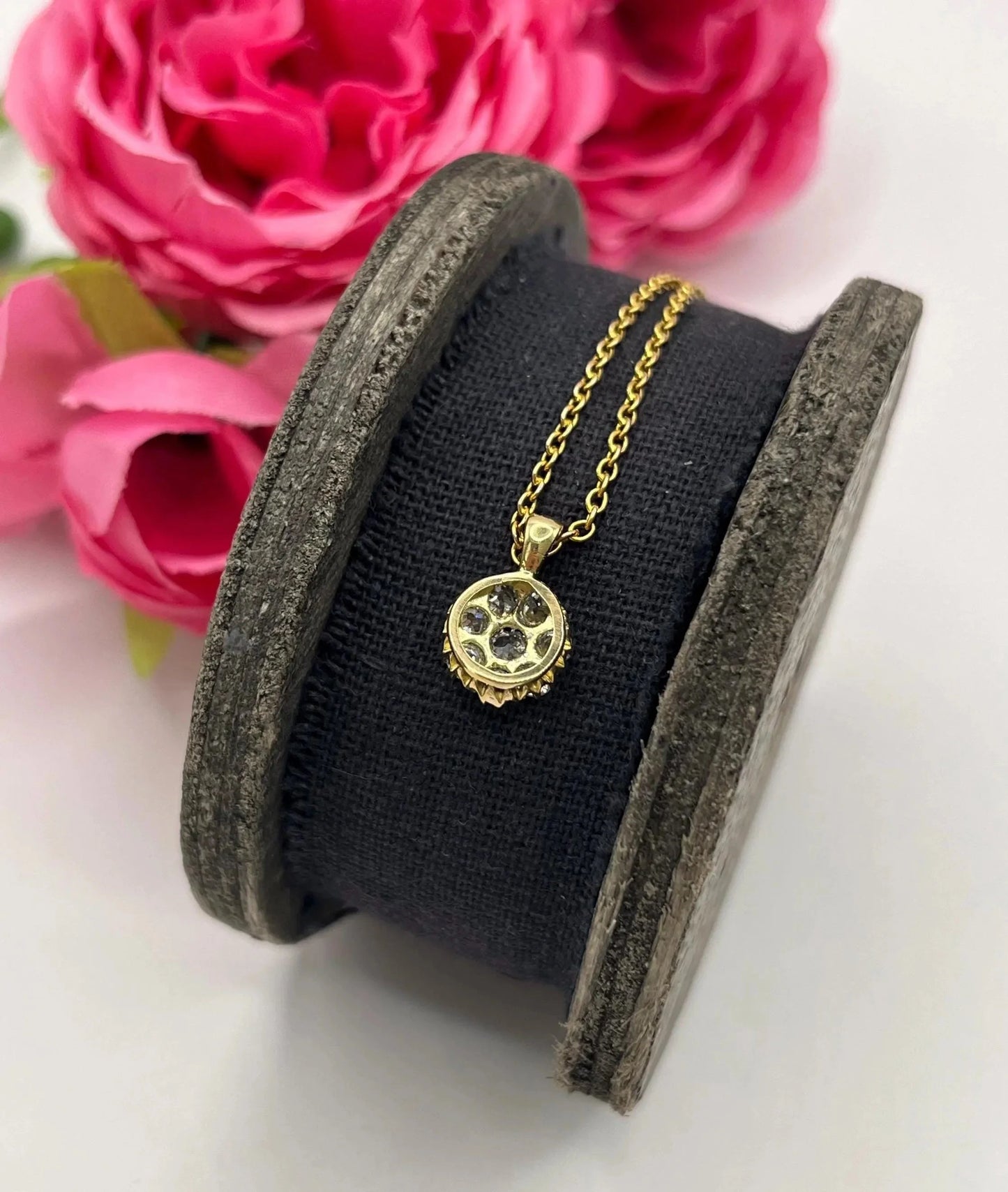 A diamond cluster pendant in yellow and white gold with a yellow gold chain