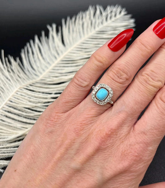 A turquoise and diamond cluster ring in platinum, modelled on a hand