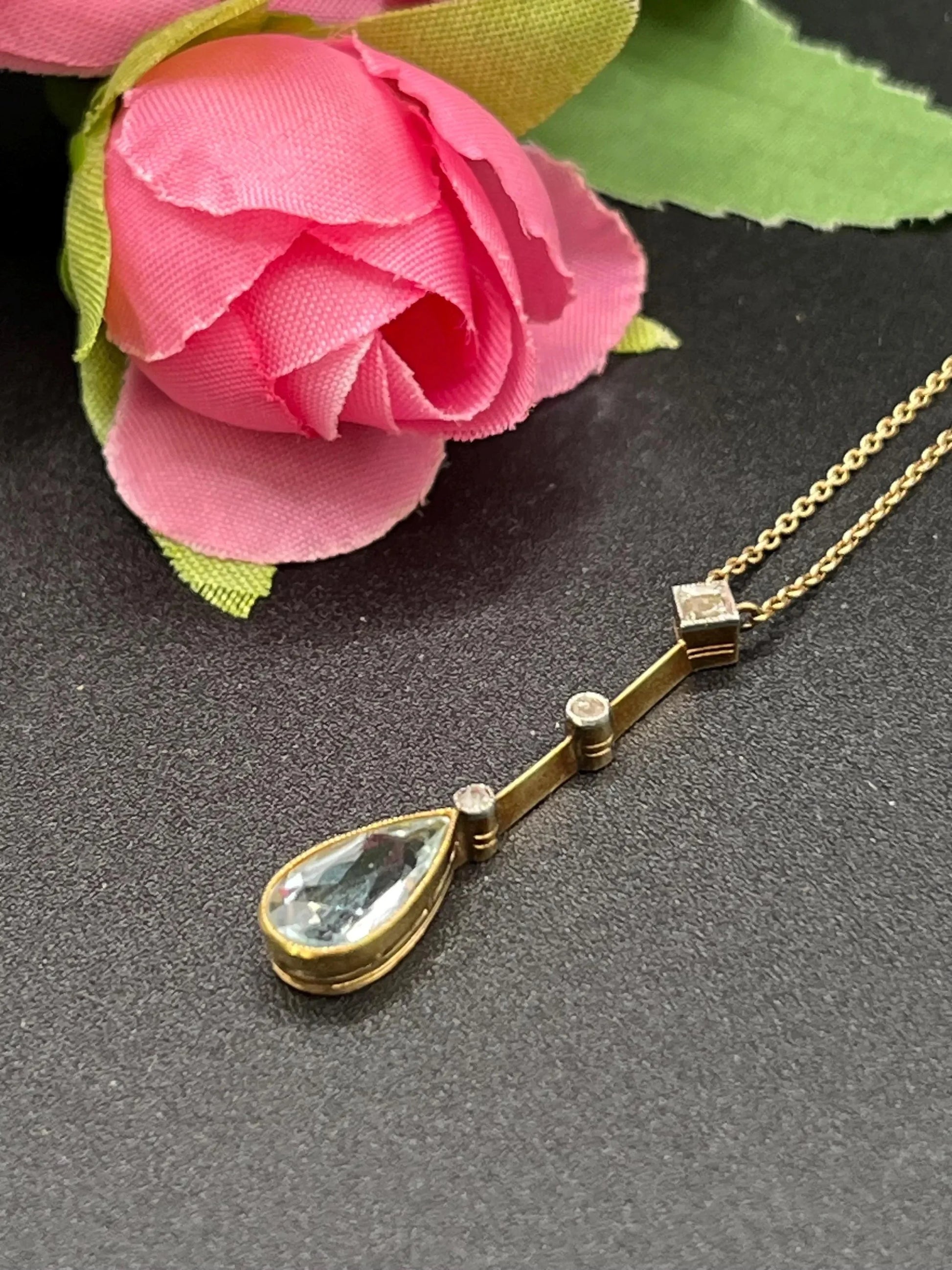 A pear shaped aquamarine and diamond drop pendant necklace in yellow gold