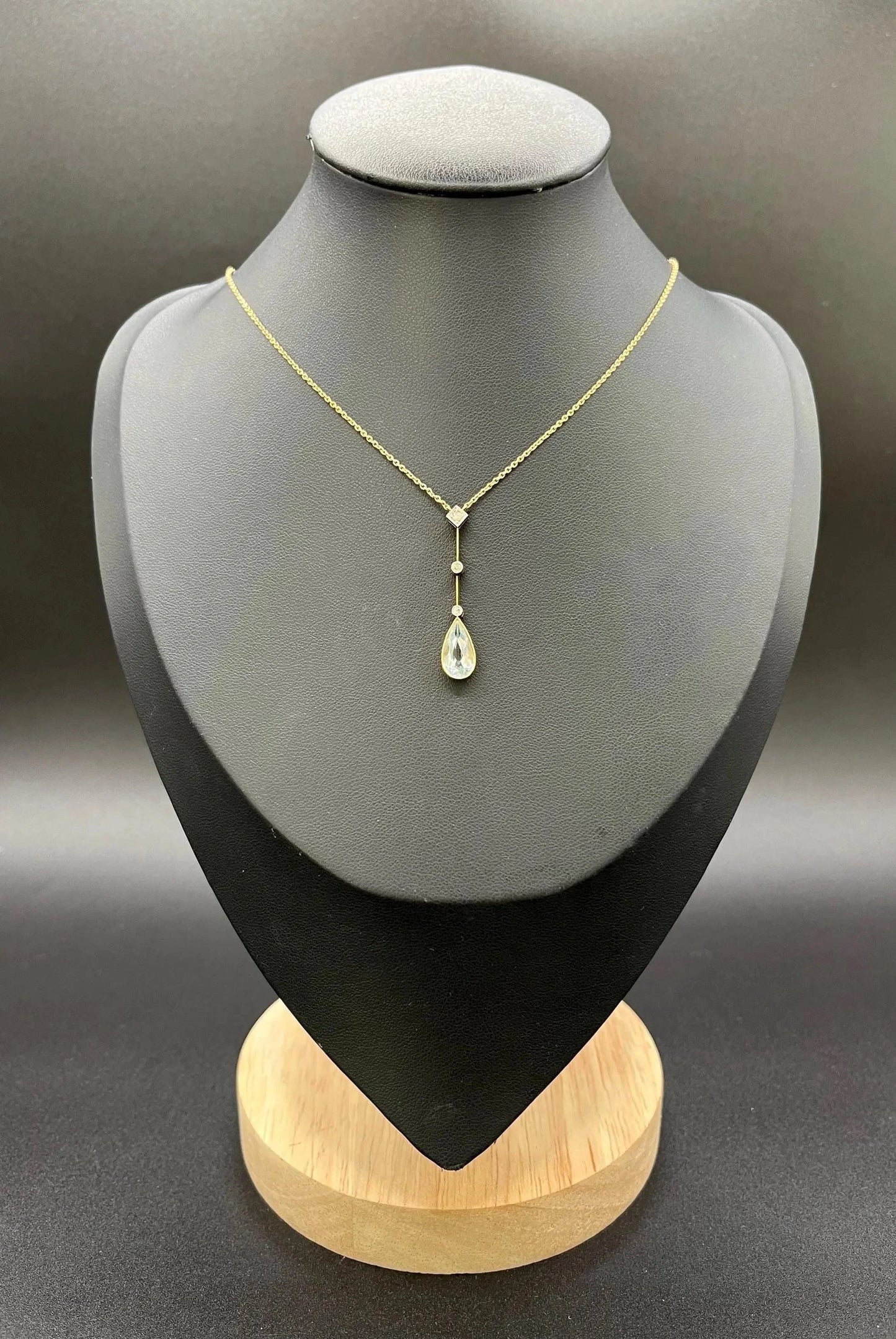 A pear shaped aquamarine and diamond drop pendant necklace in yellow gold